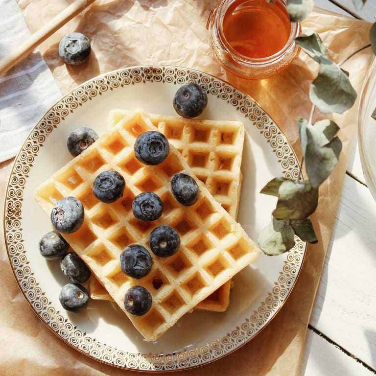 Waffles topped with blueberries and honey