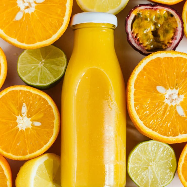 Orange juice bottle with fresh citrus fruits