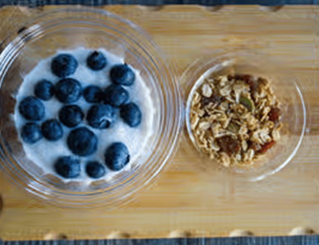 Yogurt and granola on wooden tray