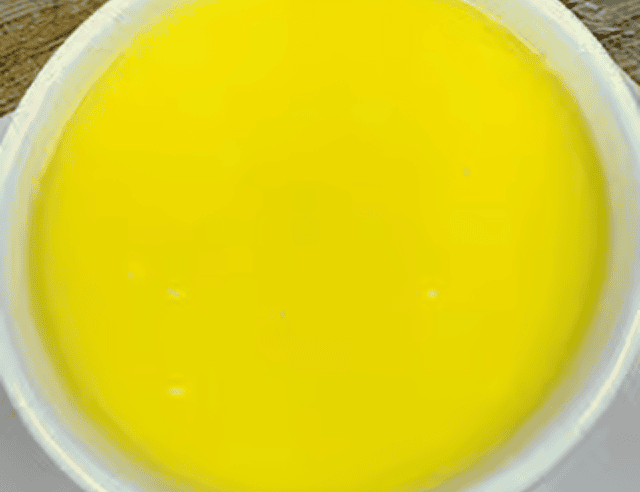 Bright yellow liquid in white cup
