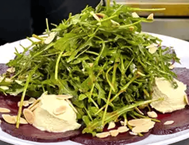 Salad garnished with almonds and cream cheese