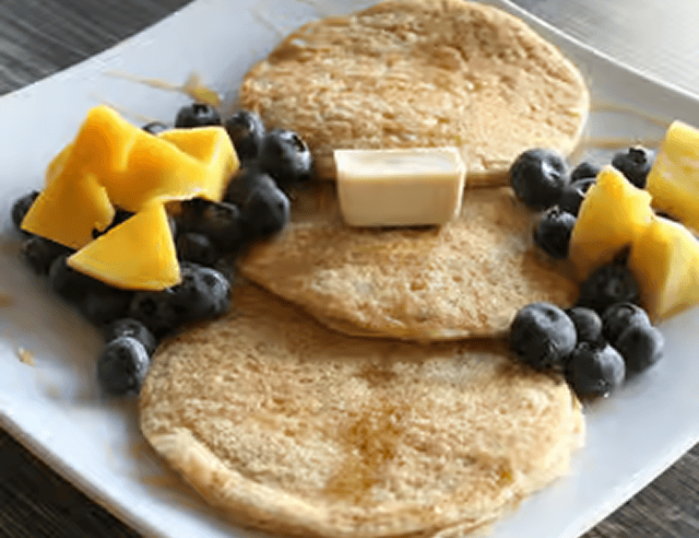 Pancakes with blueberries and mango slices