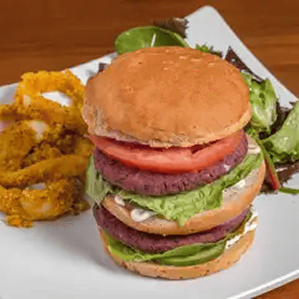 Double burger with onion rings and salad